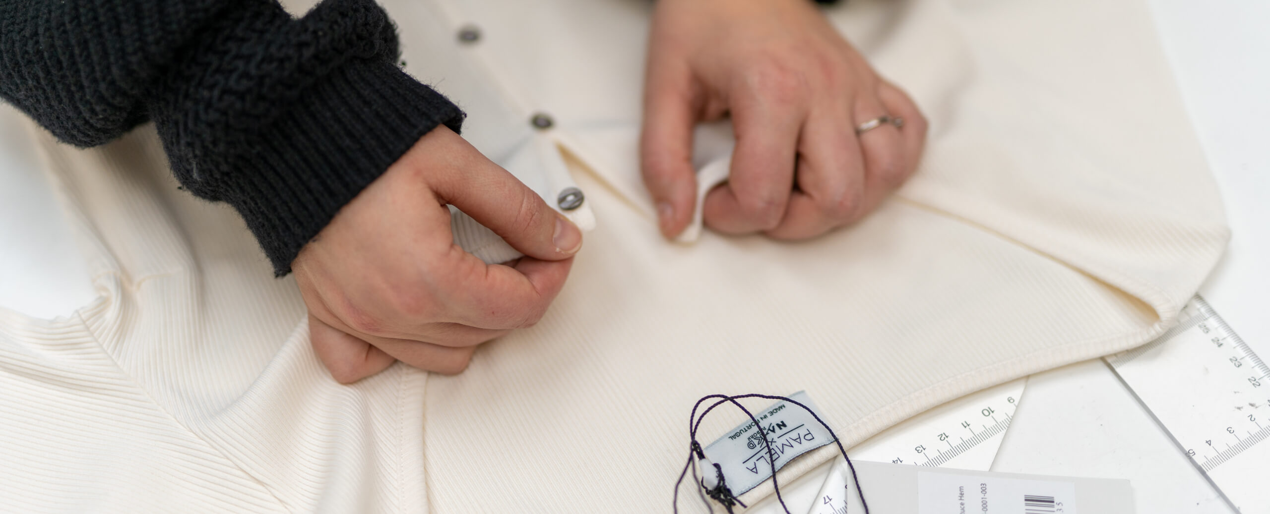 Hands undoing buttons in sweater