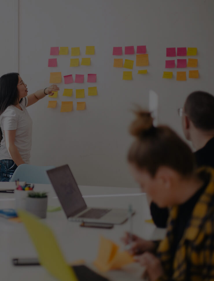 People brainstorming with post-it notes on whiteboard