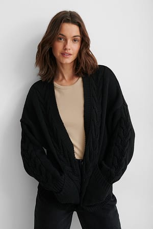 Black Recycelter kurze Strickjacke mit Zopfmuster