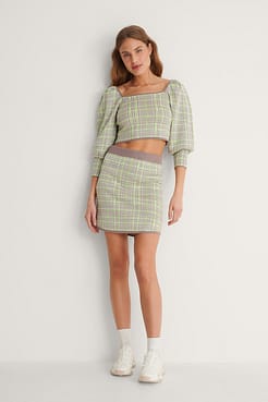 Style this checked knitted mini skirt with a knitted sweater and a pair of sneakers.